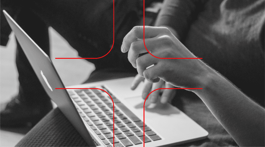 Black and white image of hands over a laptop, with a red cross-like design